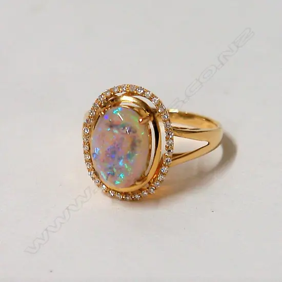 A modern 18ct. yellow gold opal and diamond ring