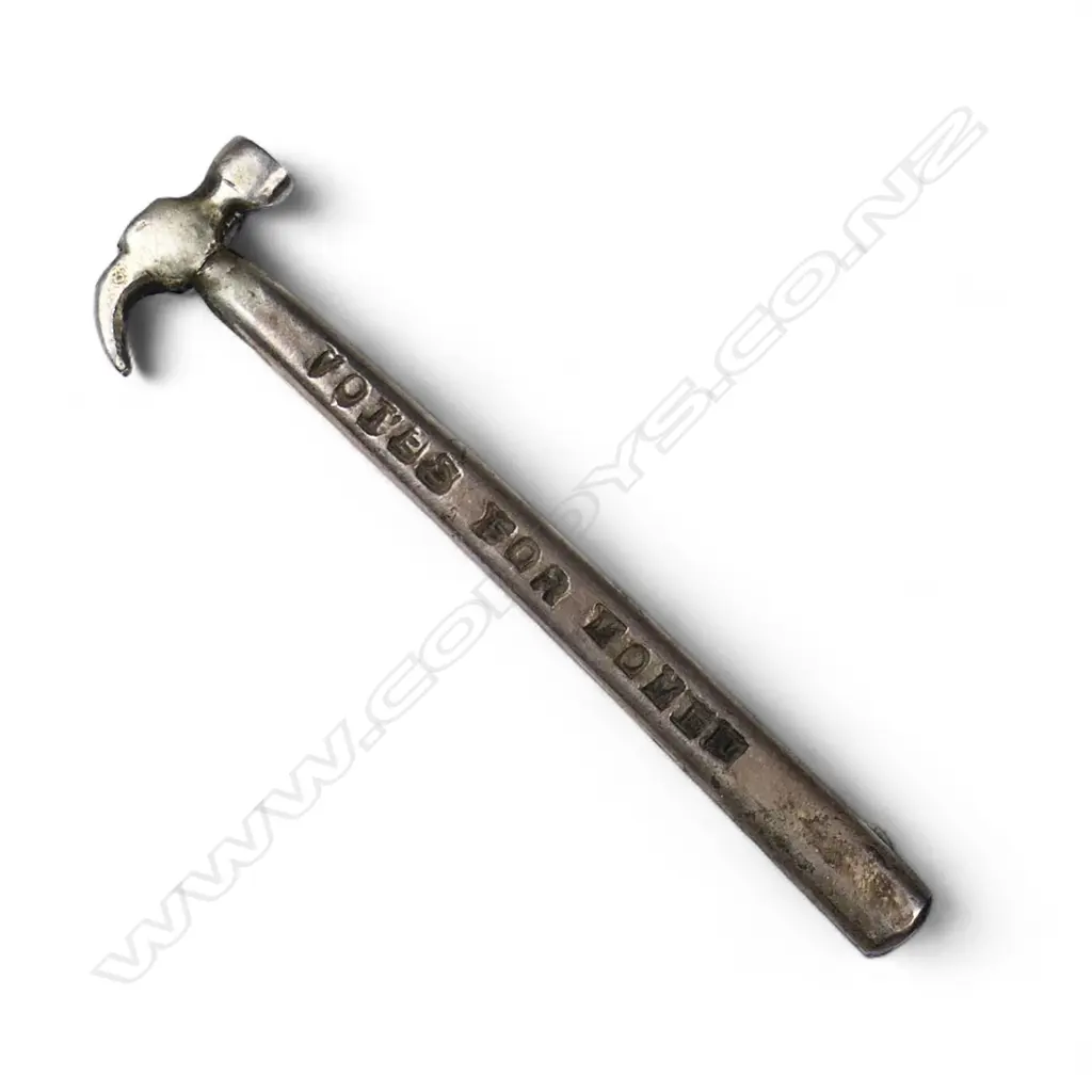 A silver brooch in the shape of a toffee or coke hammer with the inscription 'Votes for Women', Image 1++
