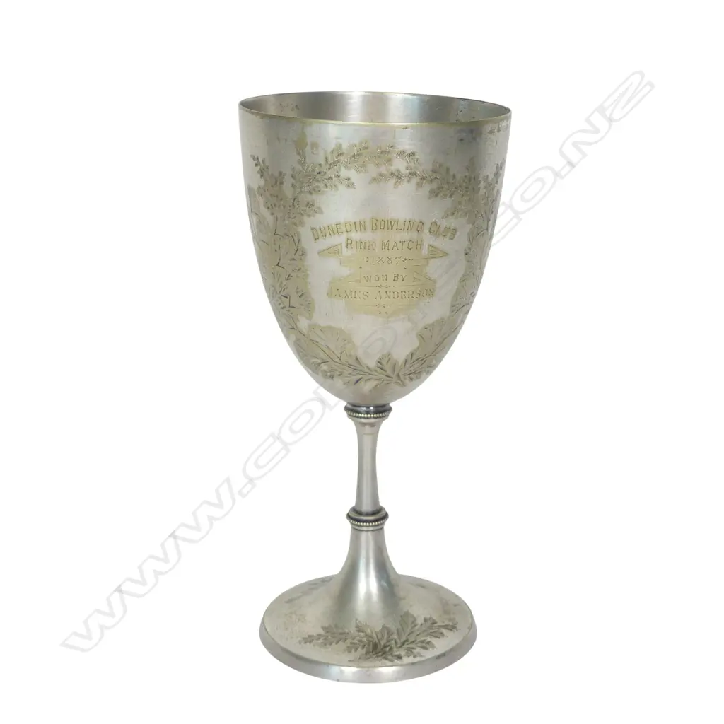 A late 19thC New Zealand historical silver plate trophy cup, presentation engraved ' Dunedin Bowling Club Rink Match 1887 Won By James Anderson. The front engraved with a bowling scene. The plating worn. H.210mm. Image 1++