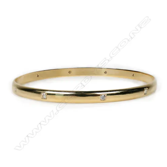 A modern 9ct yellow gold and diamond set bangle,