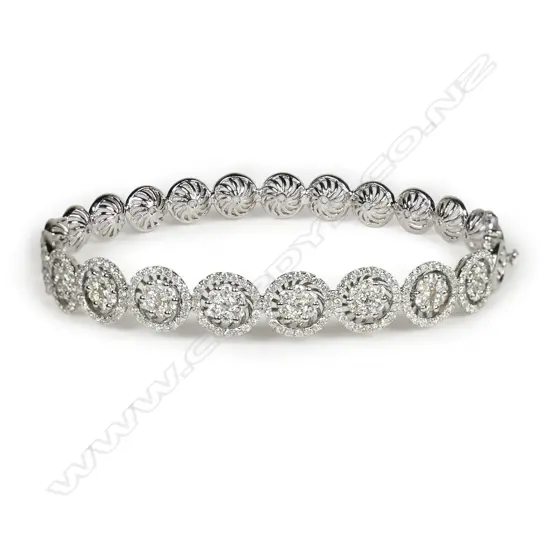 An 18ct white gold and diamond hinged bangle,