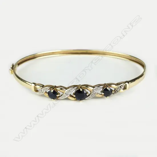 An early/mid-20thC 9ct. yellow gold sapphire and diamond hinged bangle