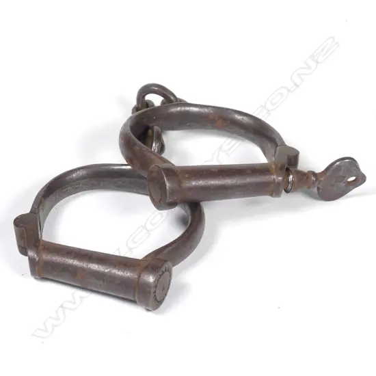 An early 20thC pair of wrought iron handcuffs