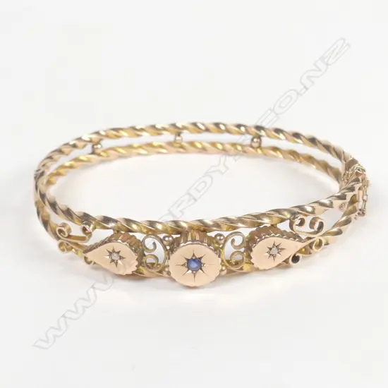 An Edwardian gilded 9ct. rose gold hinged bangle