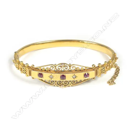 A Victorian 9ct gold diamond and ruby hinged bangle