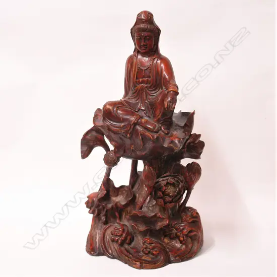 An old Chinese red lacquered carved wood figure of Guanyin raised on an elaborate base