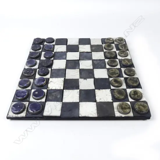 A ceramic draughts/chess board and draughts