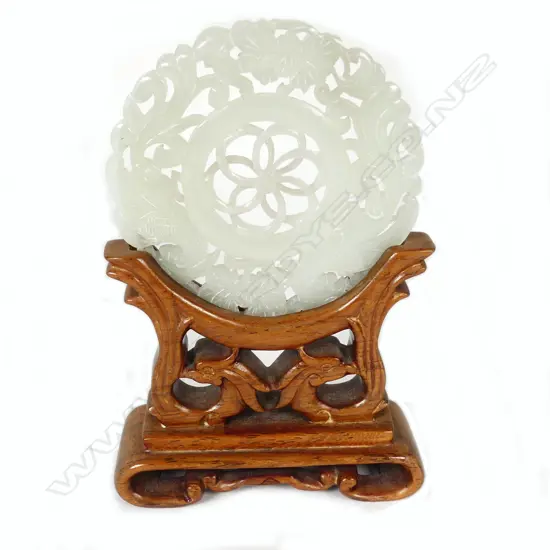 A Chinese pierced and carved chicken bone jade disc