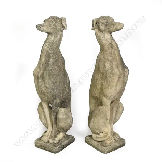 A pair of classical Church Stone greyhounds, in seated position, on small plinth base, weathered patina. H.750mm.