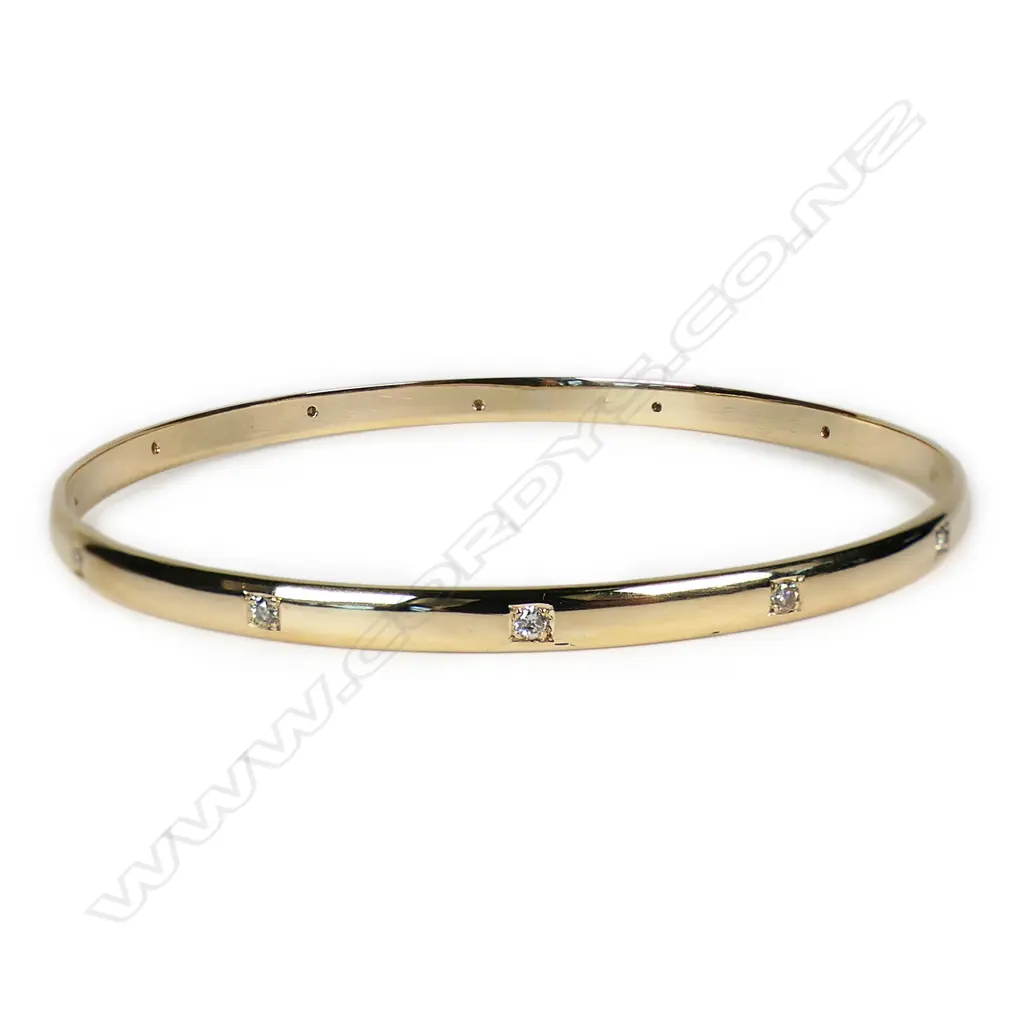 A modern 9ct yellow gold and diamond set bangle, Image 1++