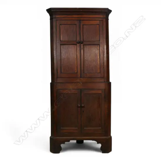 A George III oak standing two section corner cabinet,
