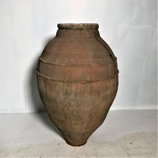 An old European terracotta tall olive oil storage jar