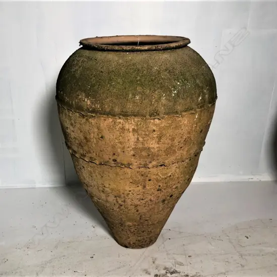 An old European terracotta tall olive oil storage jar