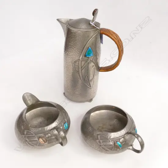 An Archibald Knox three-piece Tudric pewter part tea service