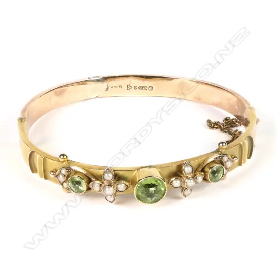 An early 1900s 9ct rose gold peridot and pearl bangle