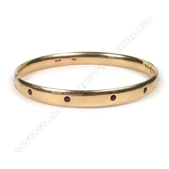 A 9ct gold and garnet hinged bangle
