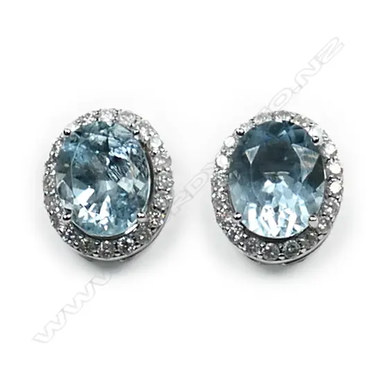 A pair of 14ct white gold aquamarine and diamond halo stud earrings, each earring set with a 2.18ct oval cut light blue aquamarine (eye clean clarity), claw set and surrounded by twenty round brilliant cut diamonds (H-I colour, SI2-I1 clarity), posts for pierced ears, TAW 4.36ct, TDW 0.58ct.