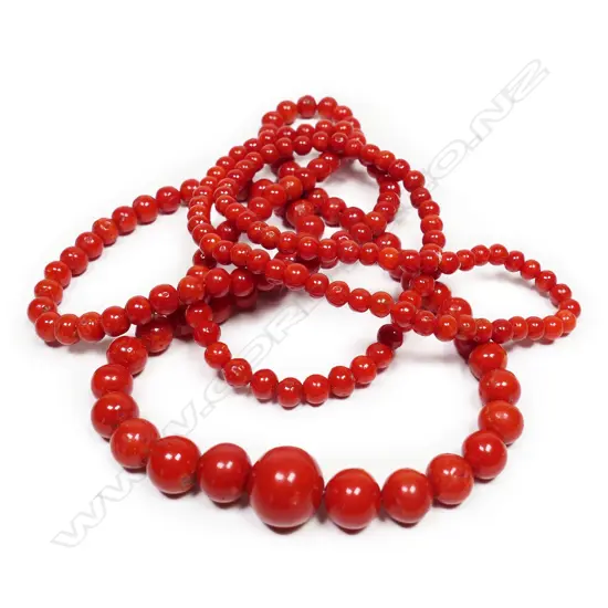 A long red coral bead necklace,