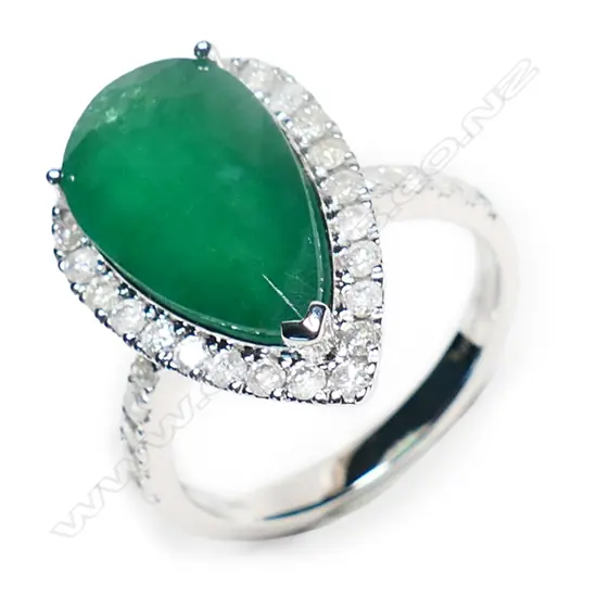A 14ct white gold, emerald and diamond halo ring,