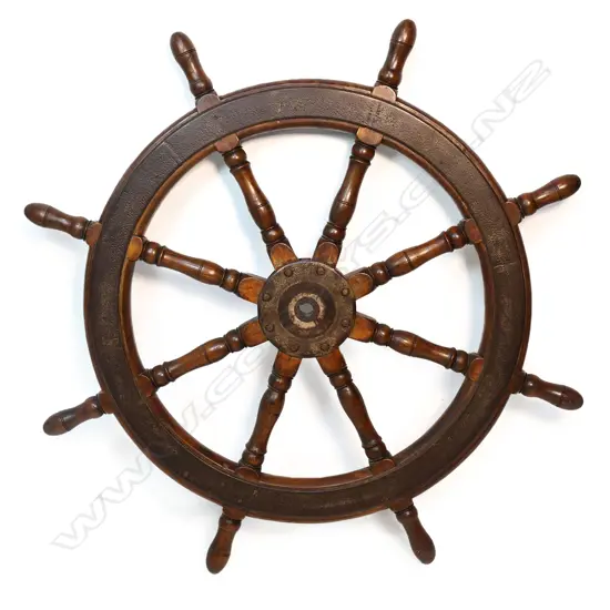 An antique ship's wheel (helm), in teak with iron strapped circumference and centre boss,