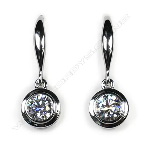 A pair of 18ct white gold and diamond solitaire earrings,