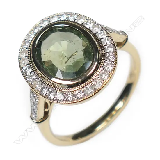 A 14ct gold, green sapphire and diamond halo ring,