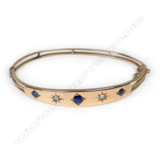 An Edwardian 9ct rose gold diamond and sapphire hinged bangle,