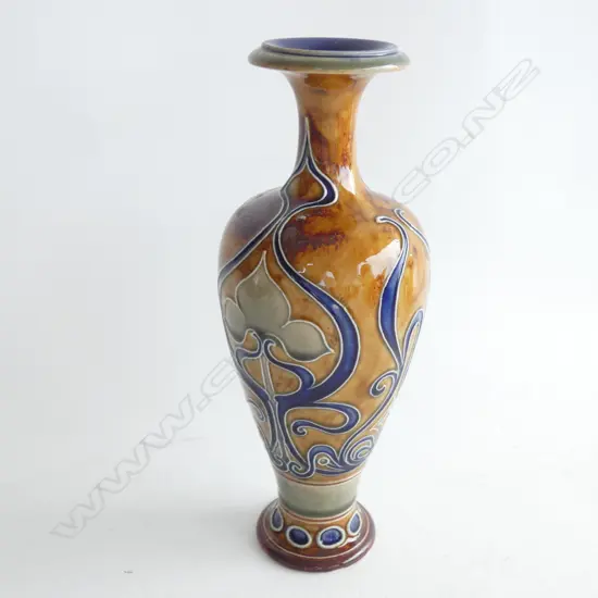 An Art Nouveau Doulton Lambeth vase by Frank Butler, caramel, brown, blue tube lined with a highly stylised Nouveau foliate pattern. Impressed marks and incised initials FAB on base. H.260mm