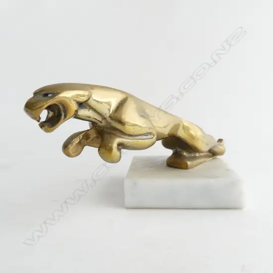 Brass jaguar car mascot on marble,