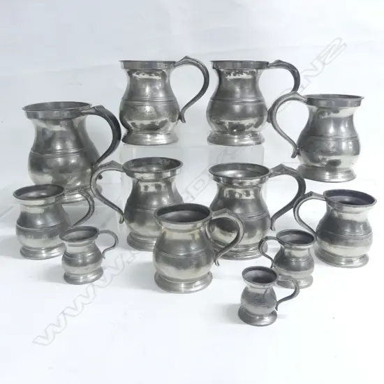 Twelve pewter baluster mugs, one of quart size, five of pint size, three of half pint and three smaller.