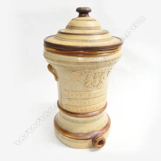 A Victorian Dahlkes stoneware water filter-, the front with ribbons ‘Dahlkes Patent Silicated Carbon Filter Co.’ and Royal crest, lidded. H.420mm.