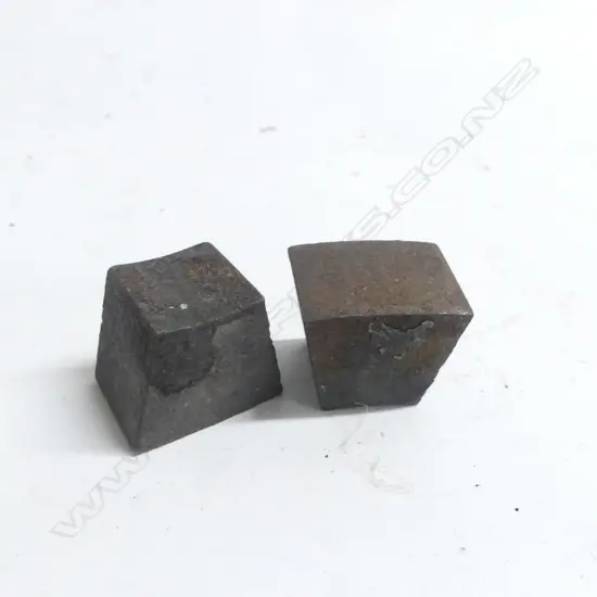 Two pieces of trapezoid steel, reputedly shrapnel from Armstrong 25-pdr gun,