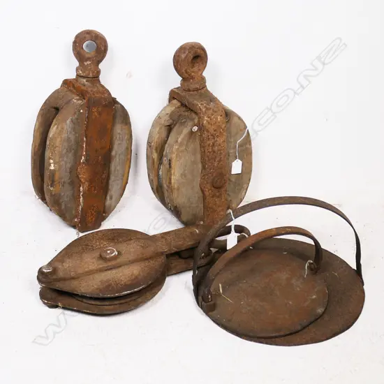 Two cast iron Griddles and three large old pulleys, one wood, one iron.