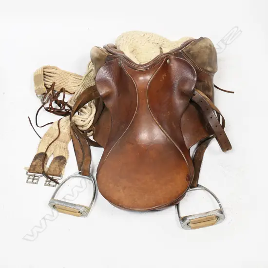 A small old leather saddle with original sheepskin blanket and girth strap
