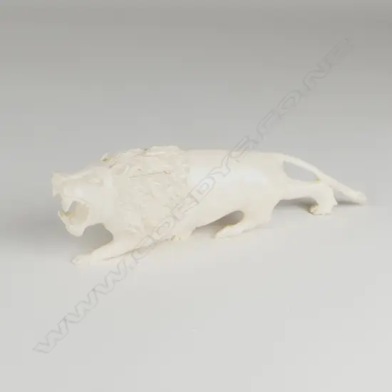A solid ivory figure of a ferocious stalking lion