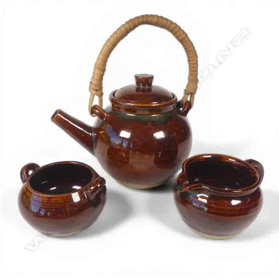 Olive Jones (1893-1982) early Rockingham-glazed teaset; cane handled teapot sugar bowl and milk jug, thick brown glaze. All signed and dated to base '28