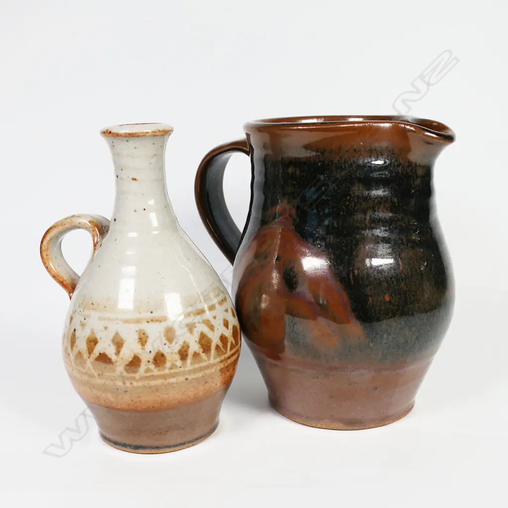 Peter Stichbury, one Shino wax resist decoration glazed jug and one tenmoku glazed jug H. 160mm both with potter's mark. Image 1++