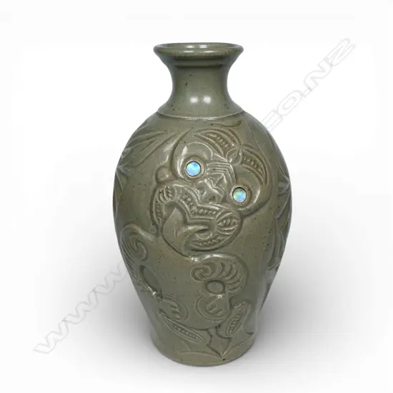 New Zealand studio pottery vase with sculpted Tiki in bas relief and inlaid paua eyes, indistinct insciption. H.300mm.