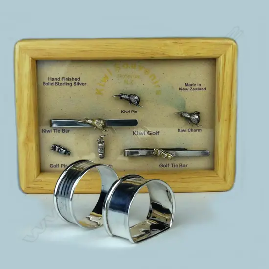 Five golfing sterling silver pins mounted in a wooden frame