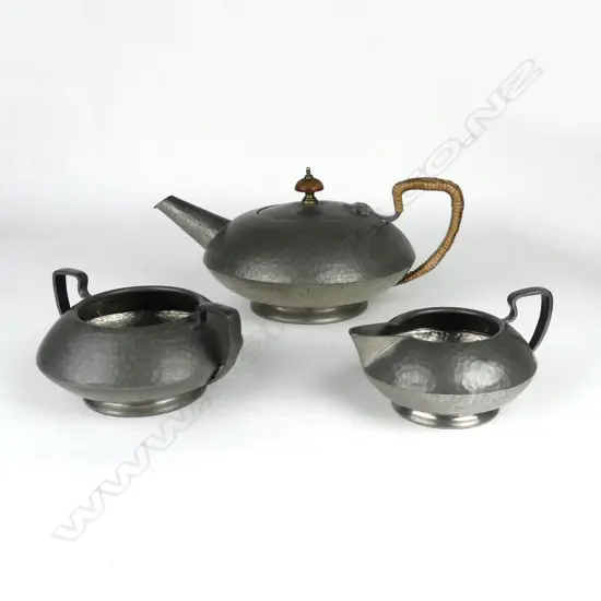 A three-piece hand beaten Tudric pewter tea set made for Liberty & Co.