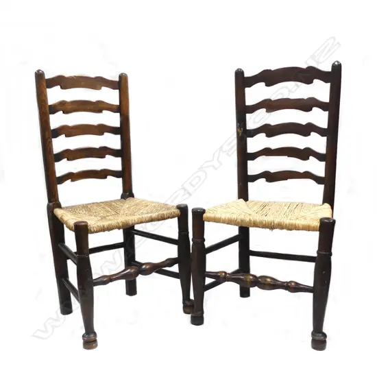 A pair of country oak rush seated ladderback chairs