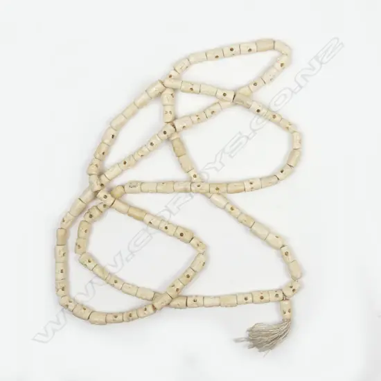 A LONG BONE NECKLACE WITH CARVED SKULL BEADS 1.7mtrs