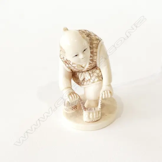 JAPANESE IVORY NETSUKE MAN TYING SANDAL 