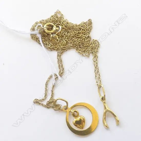TWO 14CT YELLOW GOLD PENDANTS ON CHAINS. A wishbone and a heart in a circle. One chain is 14ct