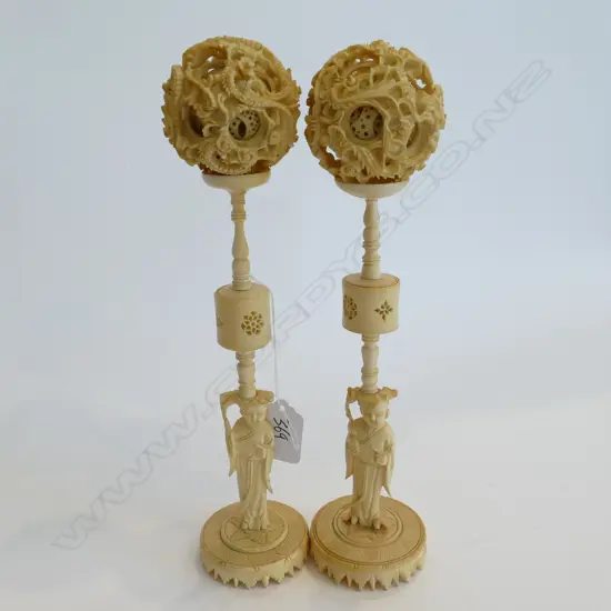 PAIR OF IVORY CARVED MULTI LAYER PUZZLE BALLS RAISED ON FIGURED STANDS. H.250mm