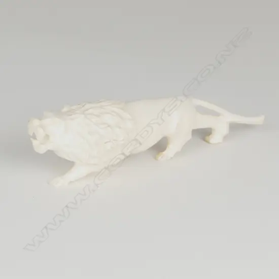 A solid ivory figure of a ferocious stalking lion