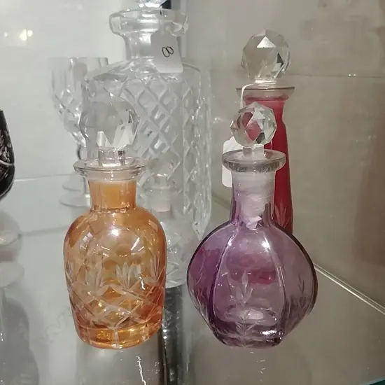 FOUR CUT GLASS COLOURED BOTTLES