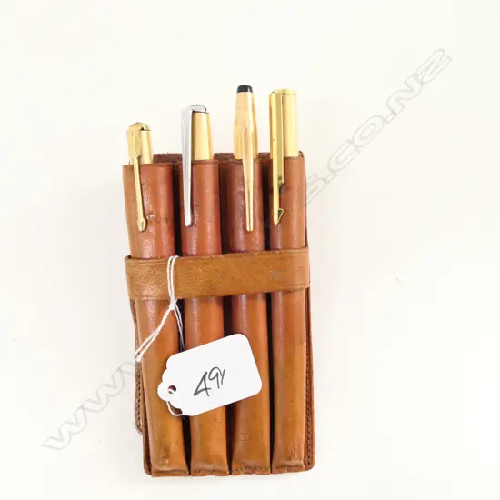 FOUR GOLD PLATED PENS IN LEATHER HOLDER