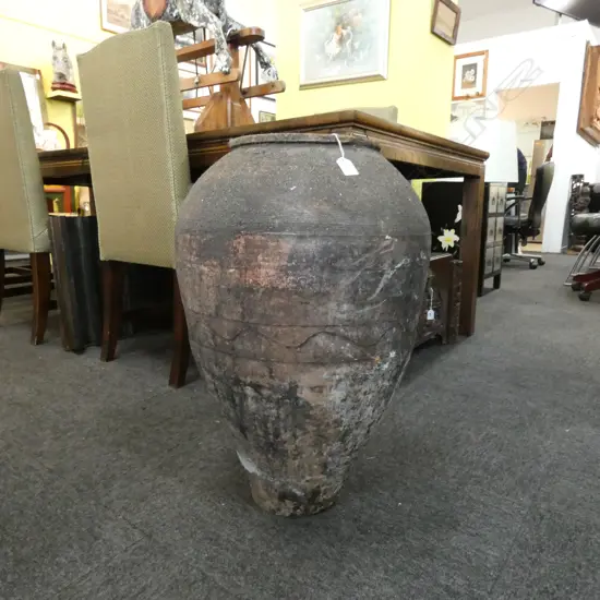 An old European terracotta tall olive oil storage jar