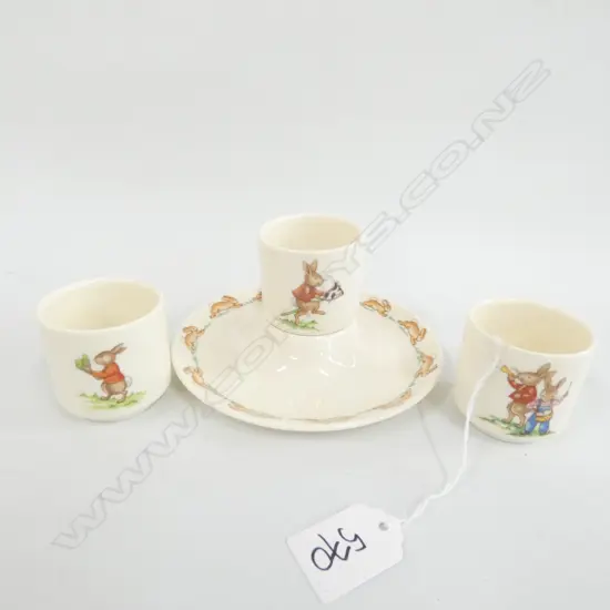 FOUR ROYAL DOULTON BUNNYKINS EGG CUPS, ONE WITH PLATE SURROUND